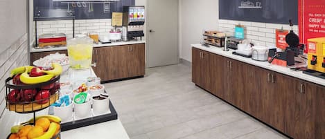 A breakfast buffet with various food items and a beverage station.