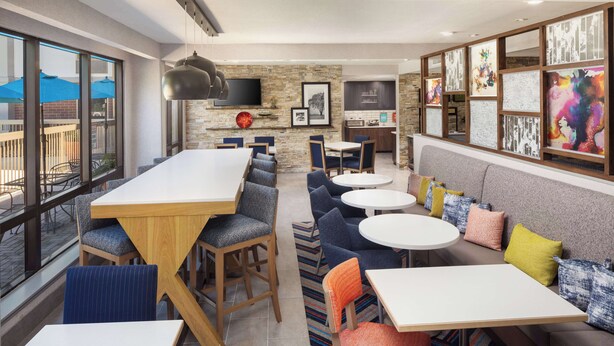 A modern restaurant with a bar area, seating arrangements, and artwork on the walls. - Hampton Inn Atlanta-Northlake (Atlanta)