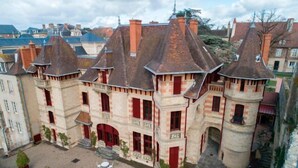 A historic building with a courtyard, red-framed windows, and a tower. - ibis Moulins Sud (Moulins)