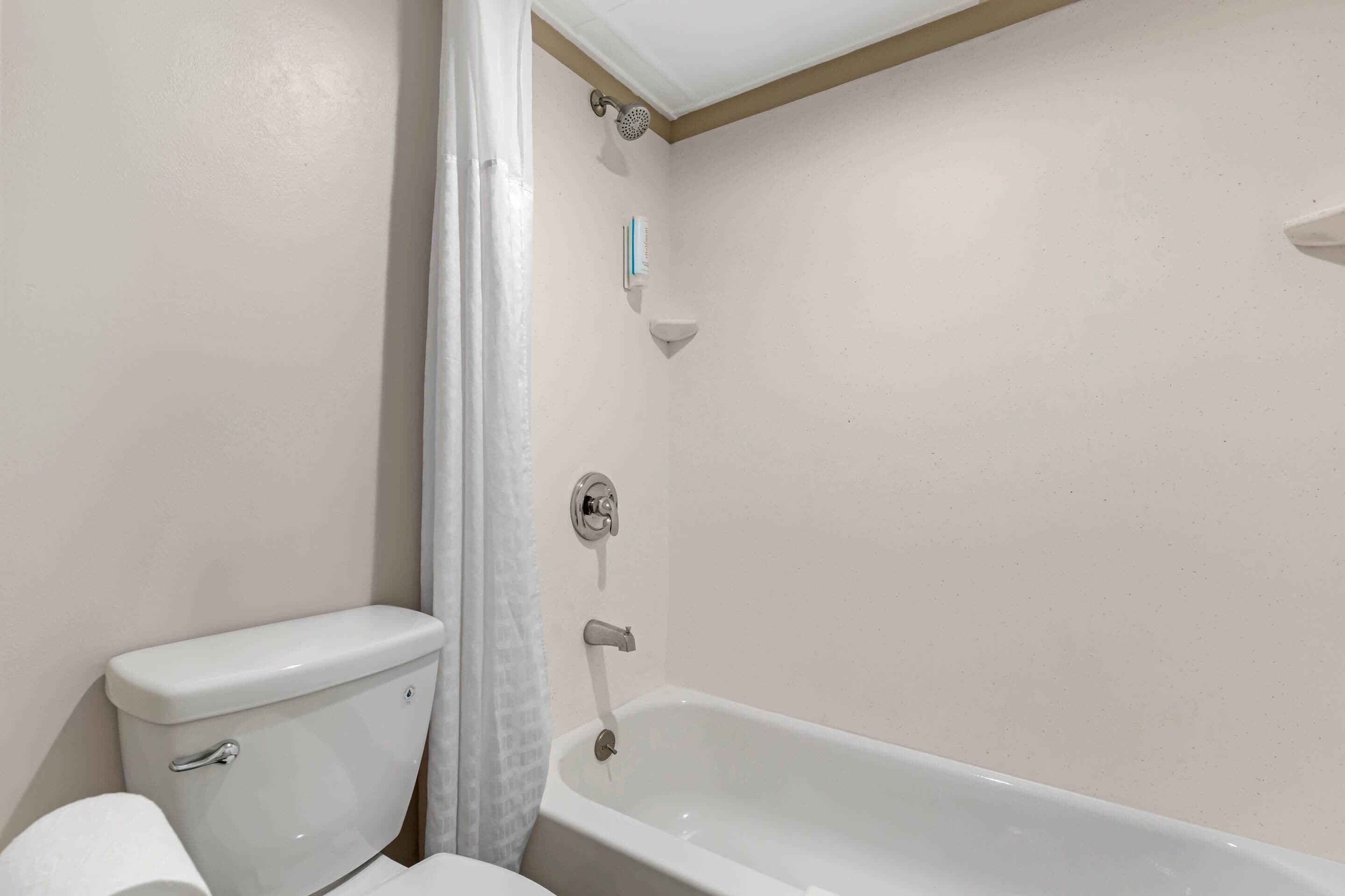 Une salle de bain équipée de toilettes, d’une baignoire et d’une douche.