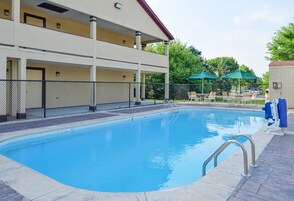 Una piscina al aire libre de temporada, sombrillas