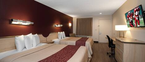 Habitación de hotel con dos camas, un escritorio, un televisor y una ventana con cortinas.
