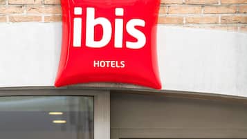 Een rood bord met de tekst 'ibis' en 'Hôtels', dat de naam van het hotel aangeeft.