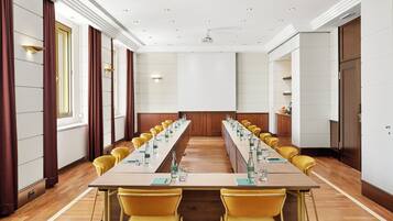 A conference room with a long table, yellow chairs, and a projector.
