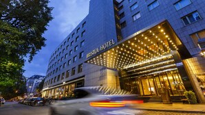 A modern hotel with a prominent entrance, large windows, and a well-lit facade. - Bristol Berlin Vignette Collection by IHG (Berlin)