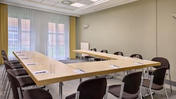 A conference room with a long table, multiple chairs, and a projector screen.