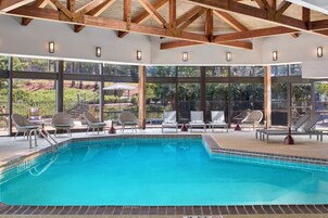 Piscina con sillas de descanso y vistas al exterior.