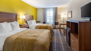 A hotel room with two beds, a desk, a television, and a window with curtains. - Quality Inn Stephens City - Winchester South (Stephens City)