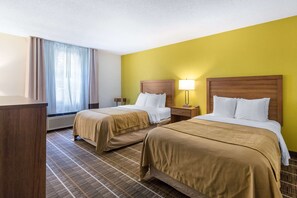 A hotel room with two beds, a desk, a lamp, and a window with curtains. - Quality Inn Stephens City - Winchester South (Stephens City)