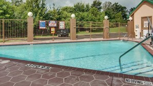 A swimming pool with a fenced area, warning signs, and a lifeguard tower. - Quality Inn Mt. Pleasant (Mount Pleasant)