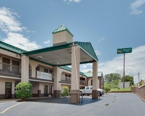 A hotel with a covered entrance, a sign indicating it's a Quality Inn, and a Gold Award Winner sign.