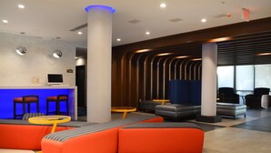 Una hall moderna con una reception, zone relax e un'ampia finestra.