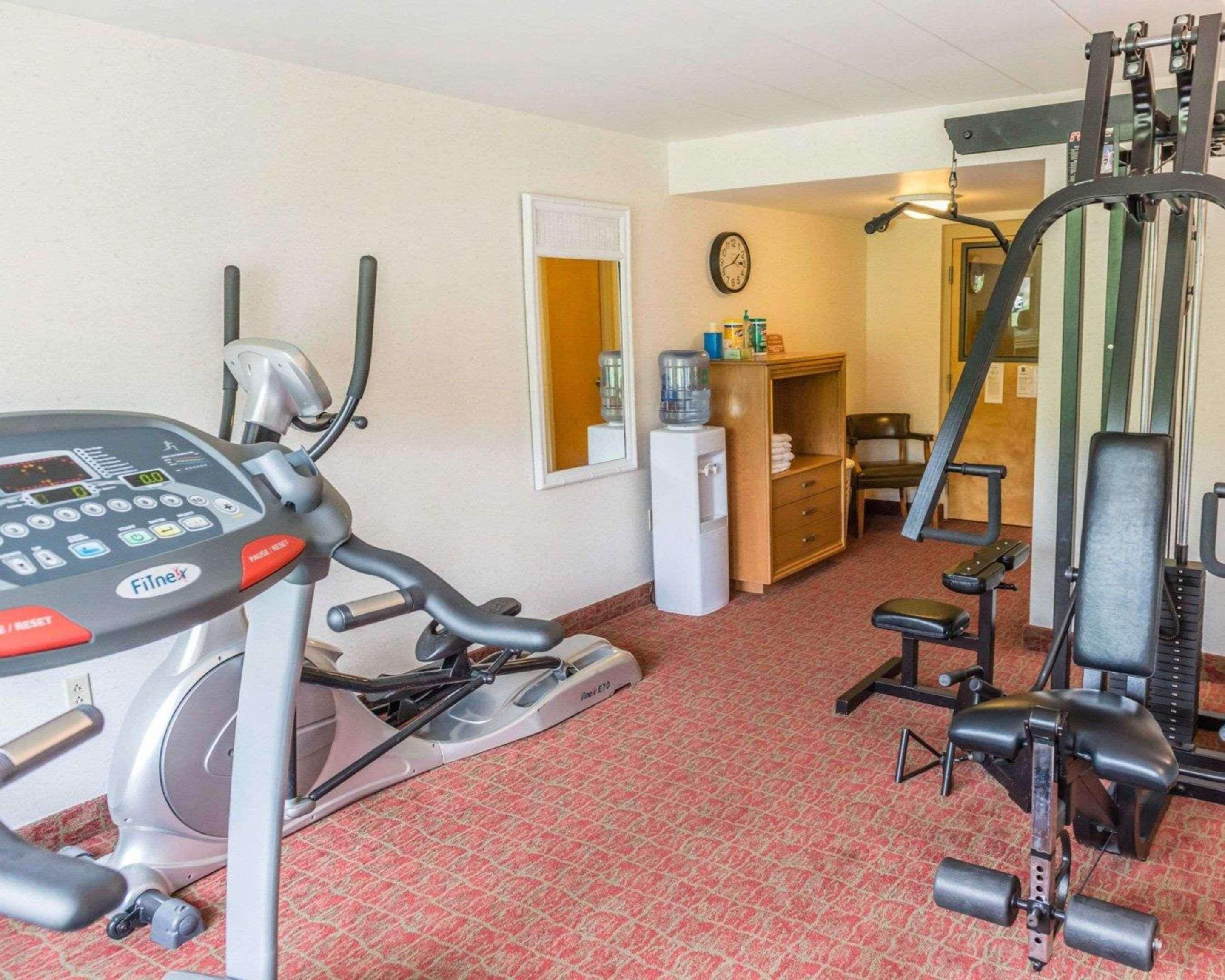 A compact gym with a treadmill, elliptical, and weight machines.