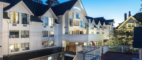 Un hotel de varios pisos con un llamativo letrero 'Huntingdon', con balcones, ventanas grandes y una base de piedra.