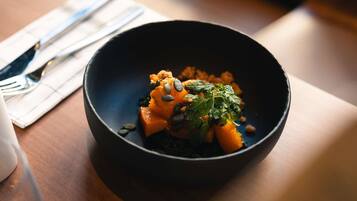 A dark bowl with food on a table.
