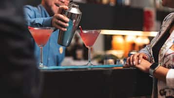 A bar setting with a bartender preparing drinks.