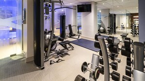 A gym with various exercise equipment, a television, and a wall with the text 'In Balance Wellness'.