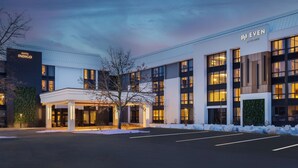 Un hôtel moderne doté d’une entrée couverte, de grandes fenêtres et d’une façade bien éclairée.