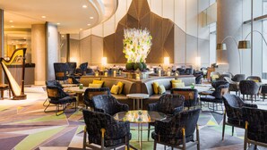 A modern hotel lobby with a central seating area, a decorative wall, and a staircase. - Swissotel Nankai Osaka (Osaka)