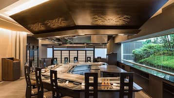 Una cocina moderna con una isla central, electrodomésticos de acero inoxidable y vistas al exterior.
