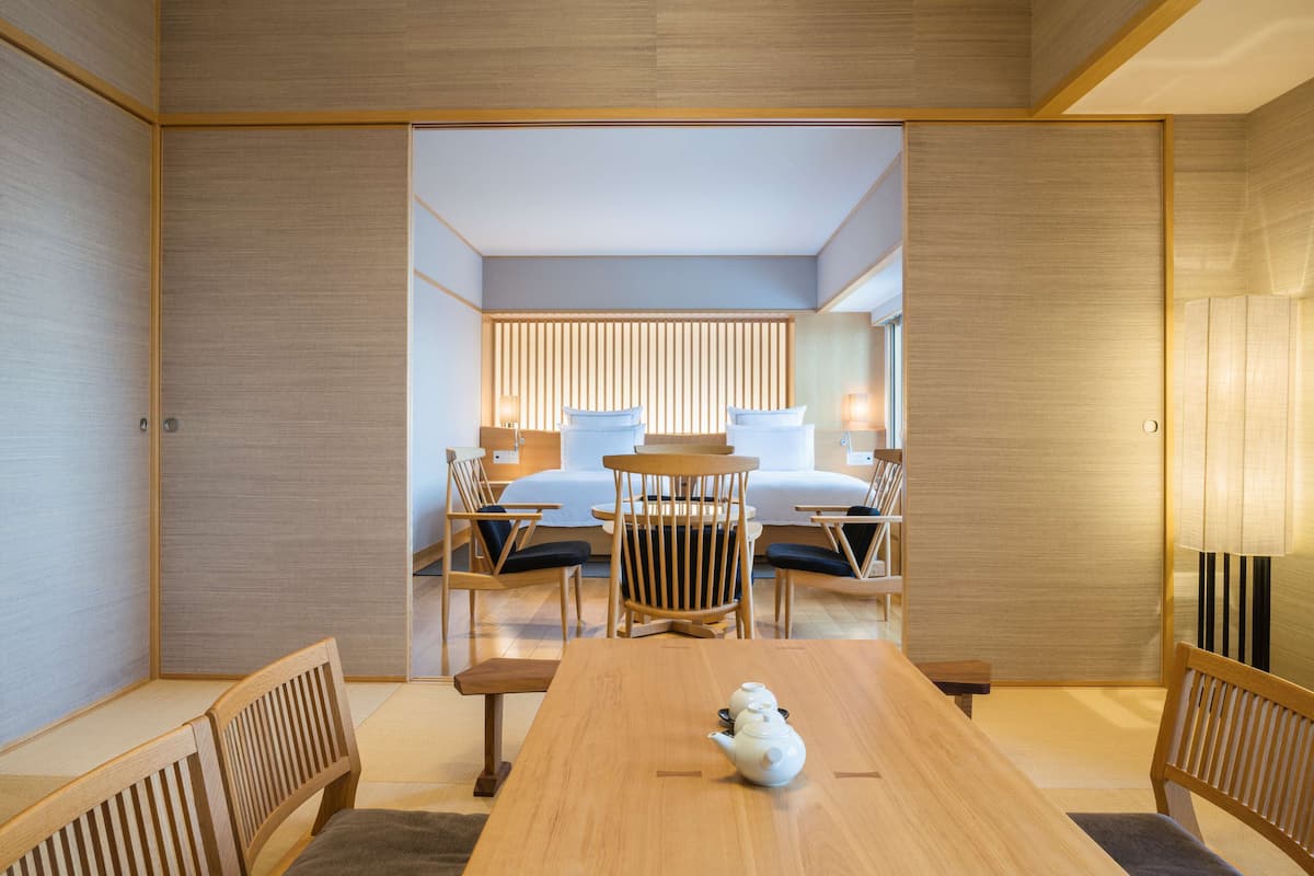 A traditional Japanese-style room with tatami flooring, a low wooden table, and a tea set.