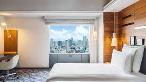A hotel room with a city view, a bed, a desk, and a chair. - Swissotel Nankai Osaka (Osaka)