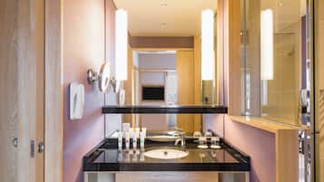 A modern bathroom with a black countertop, two sinks, a large mirror, and a glass shower enclosure.