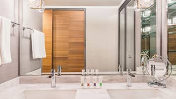 Une salle de bain moderne avec deux lavabos, une porte en bois et un grand miroir.