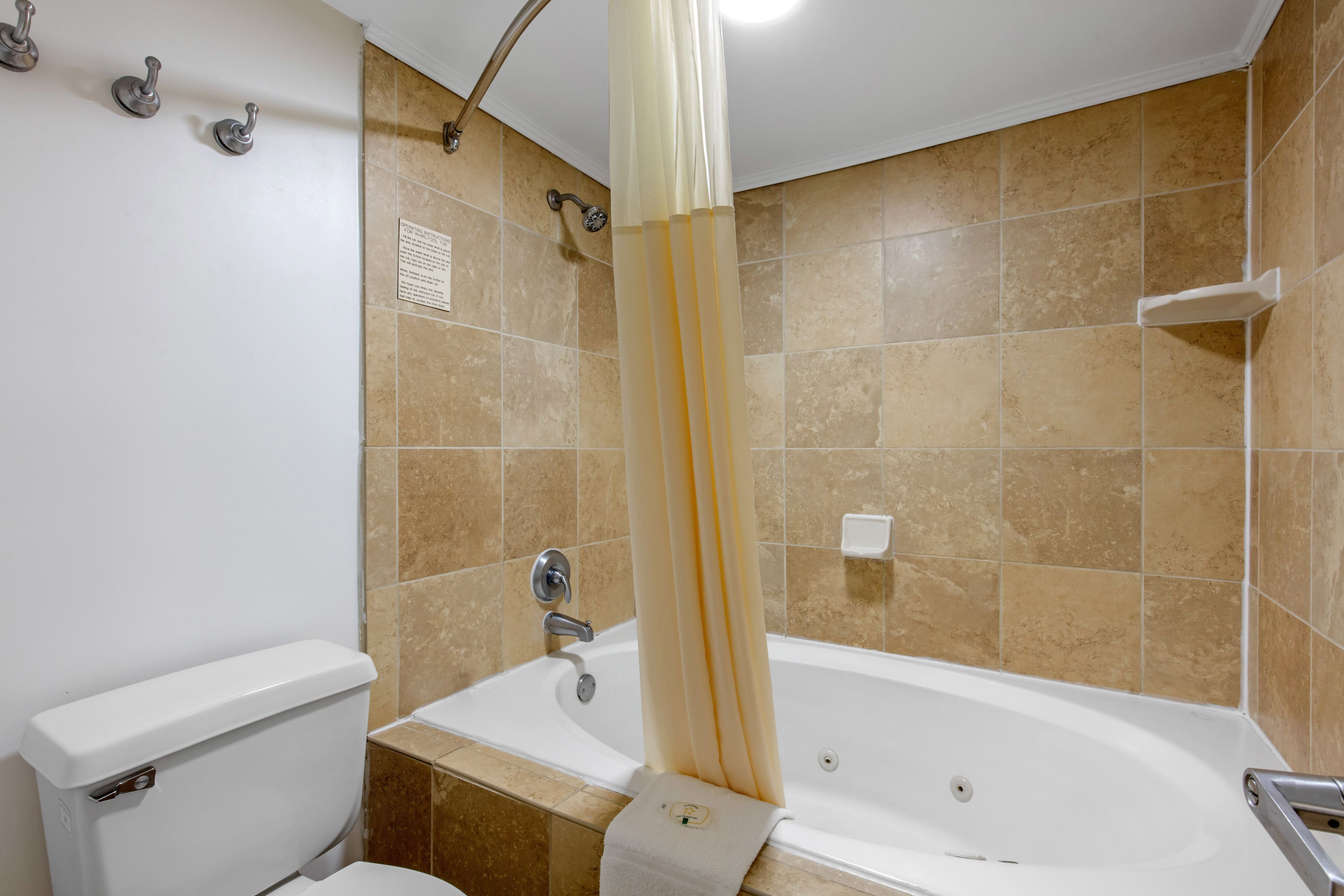 Une salle de bain avec une baignoire, des toilettes et un rideau de douche.