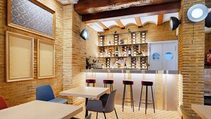 Un restaurant amb zona de bar, parets de fusta i diverses opcions de seients, incloent tamborets i cadires.