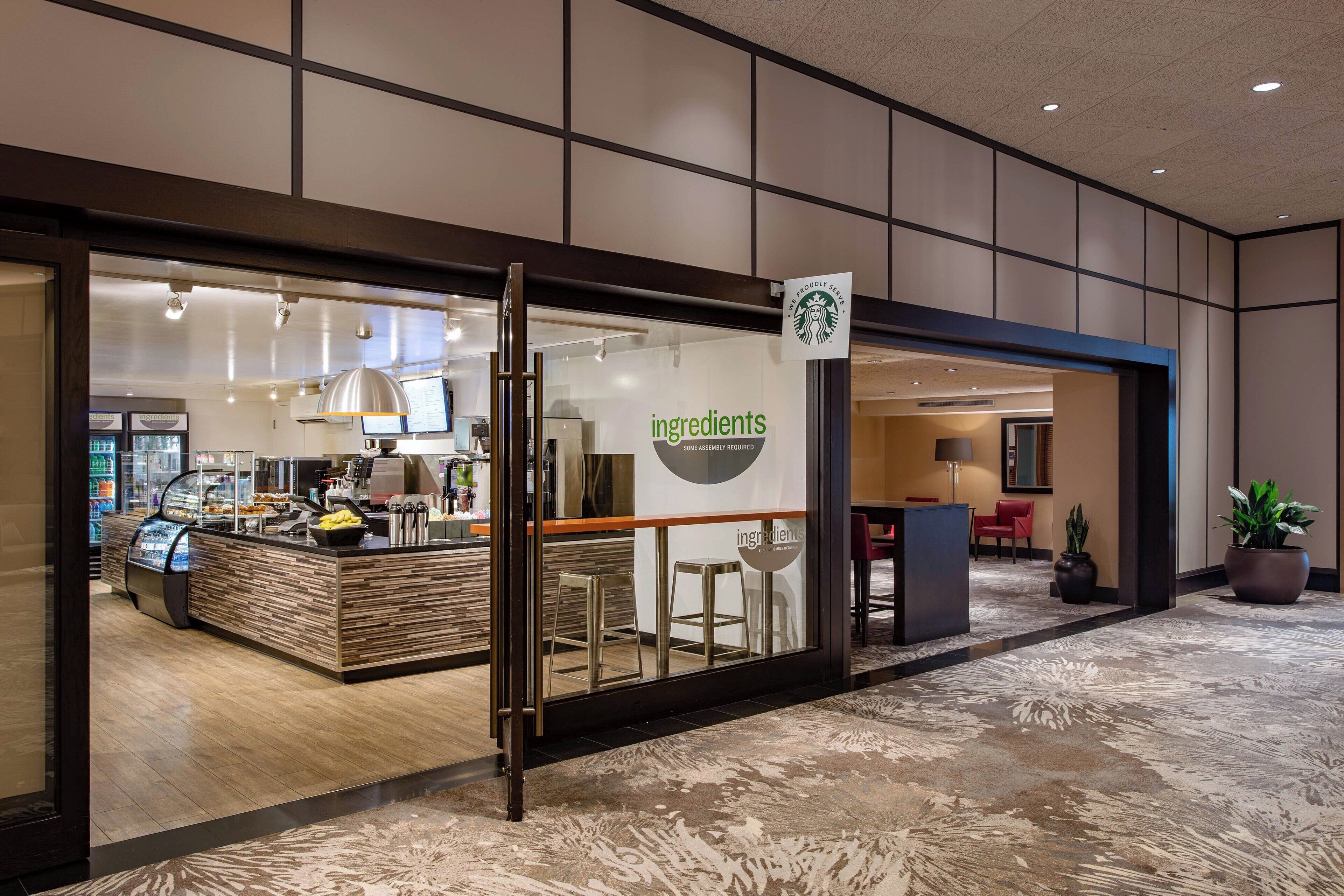 Una Starbucks con un interior moderno, que incluye una barra con la carta de menú y una zona de estar.