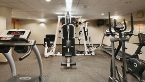 A gym with various exercise equipment including treadmills, a stationary bike, and weight machines. - Flamingo Hotel (Medicine Hat)