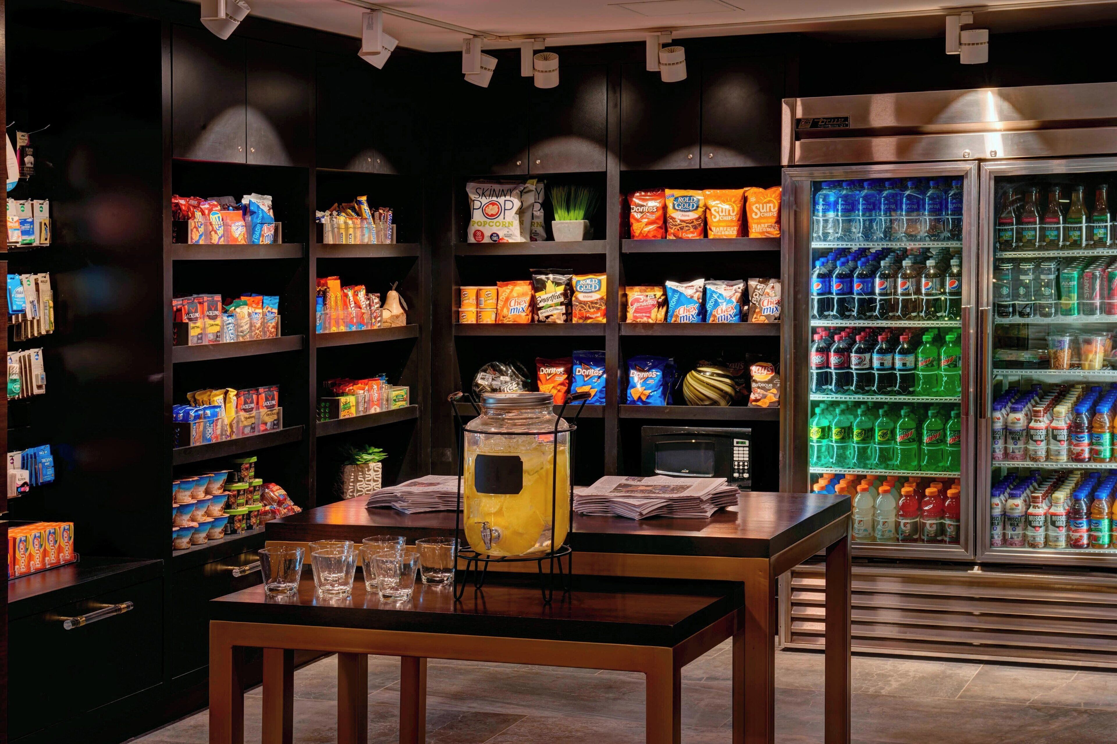 A snack bar with shelves stocked with various snacks and a beverage dispenser.