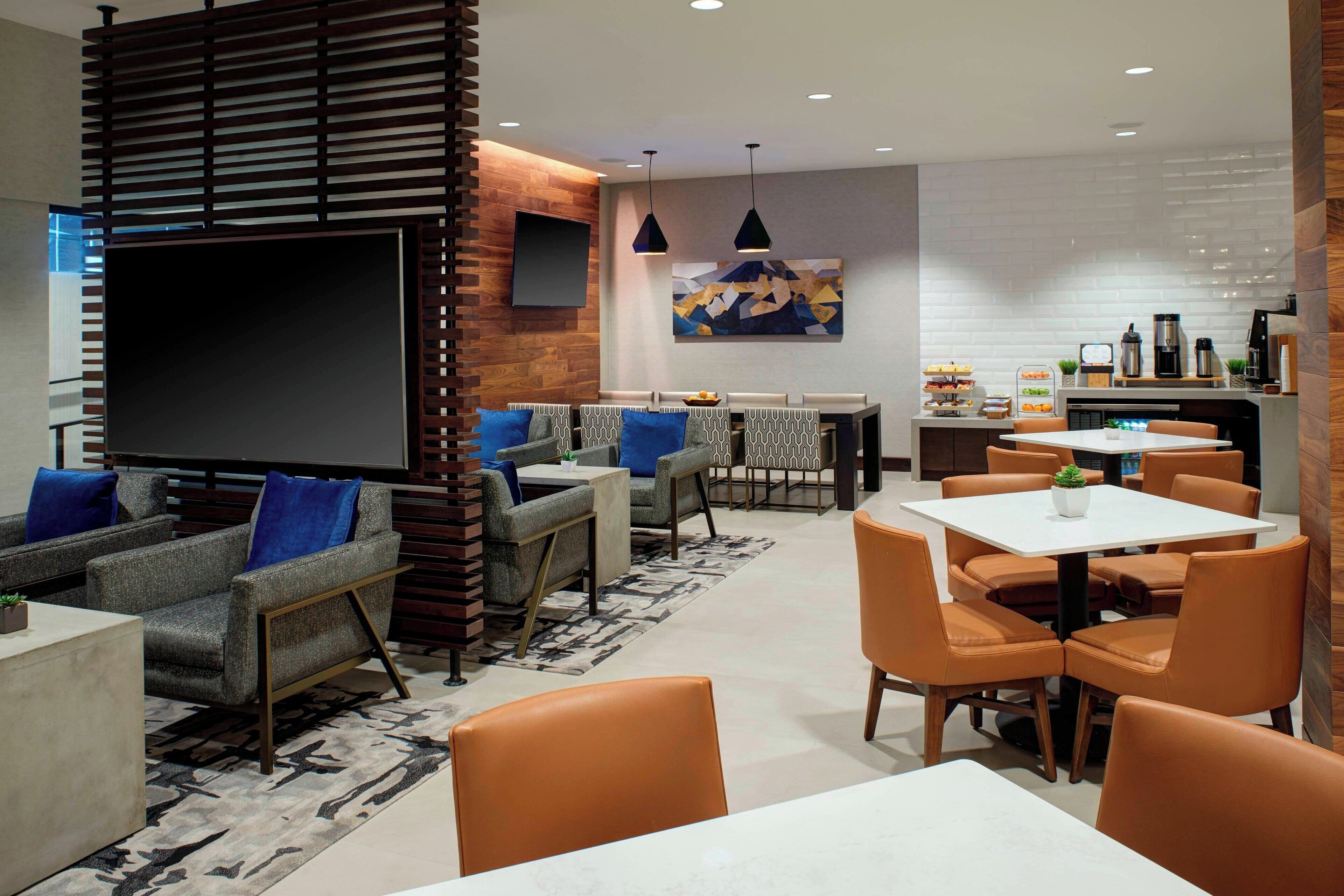 Ein moderner Lounge-Bereich mit Sofas, Sesseln und einem Esstisch.