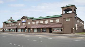 A Days Inn hotel with a green roof, multiple storefronts, and a live music venue.