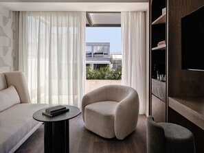 A modern living room with a sofa, armchair, and a small table with books. - Electra Rhythm Athens (Athens)