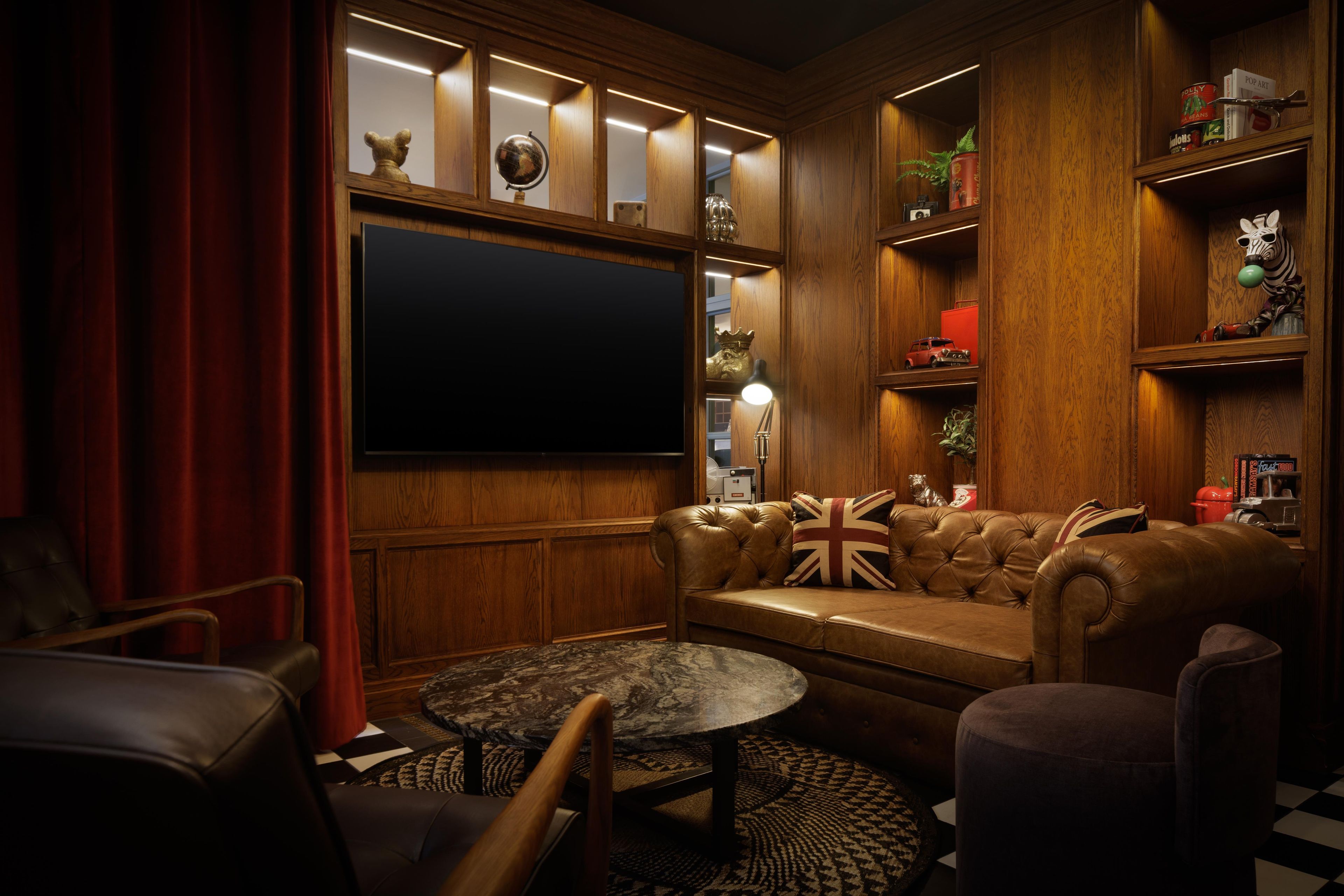 Ein gemütliches Wohnzimmer mit einem Ledersofa, einem runden Couchtisch und einem Fernseher.