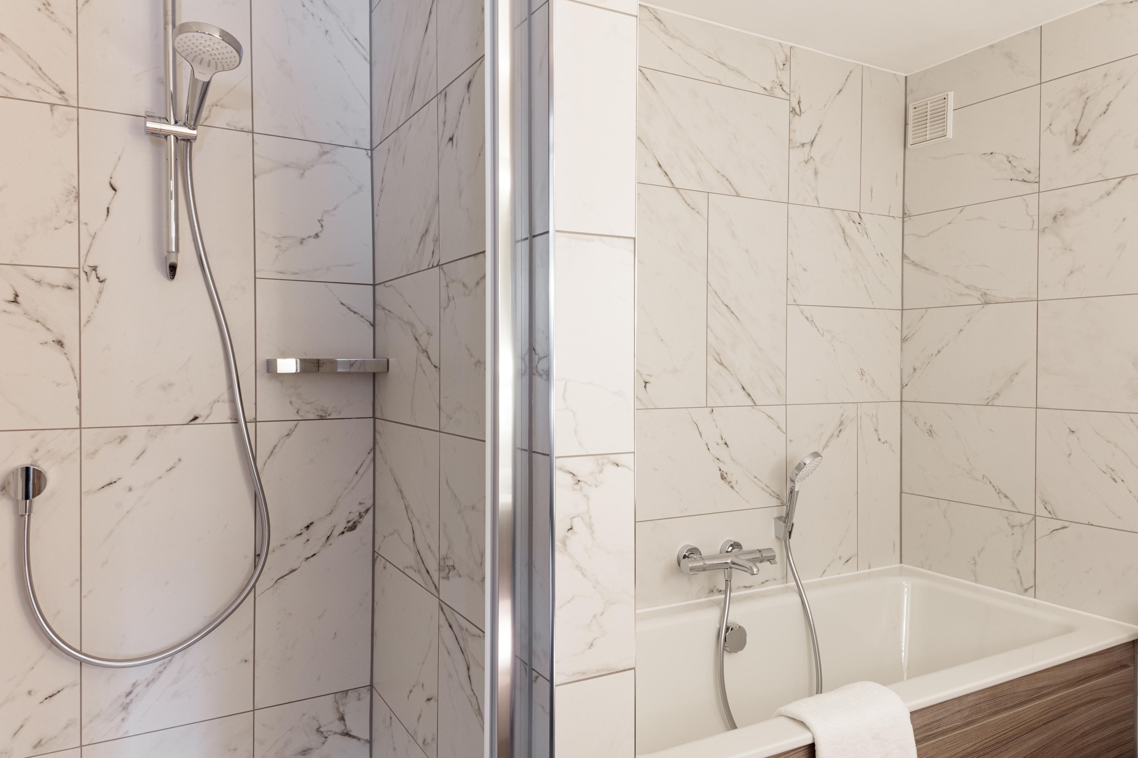Un baño con ducha, bañera y retrete.