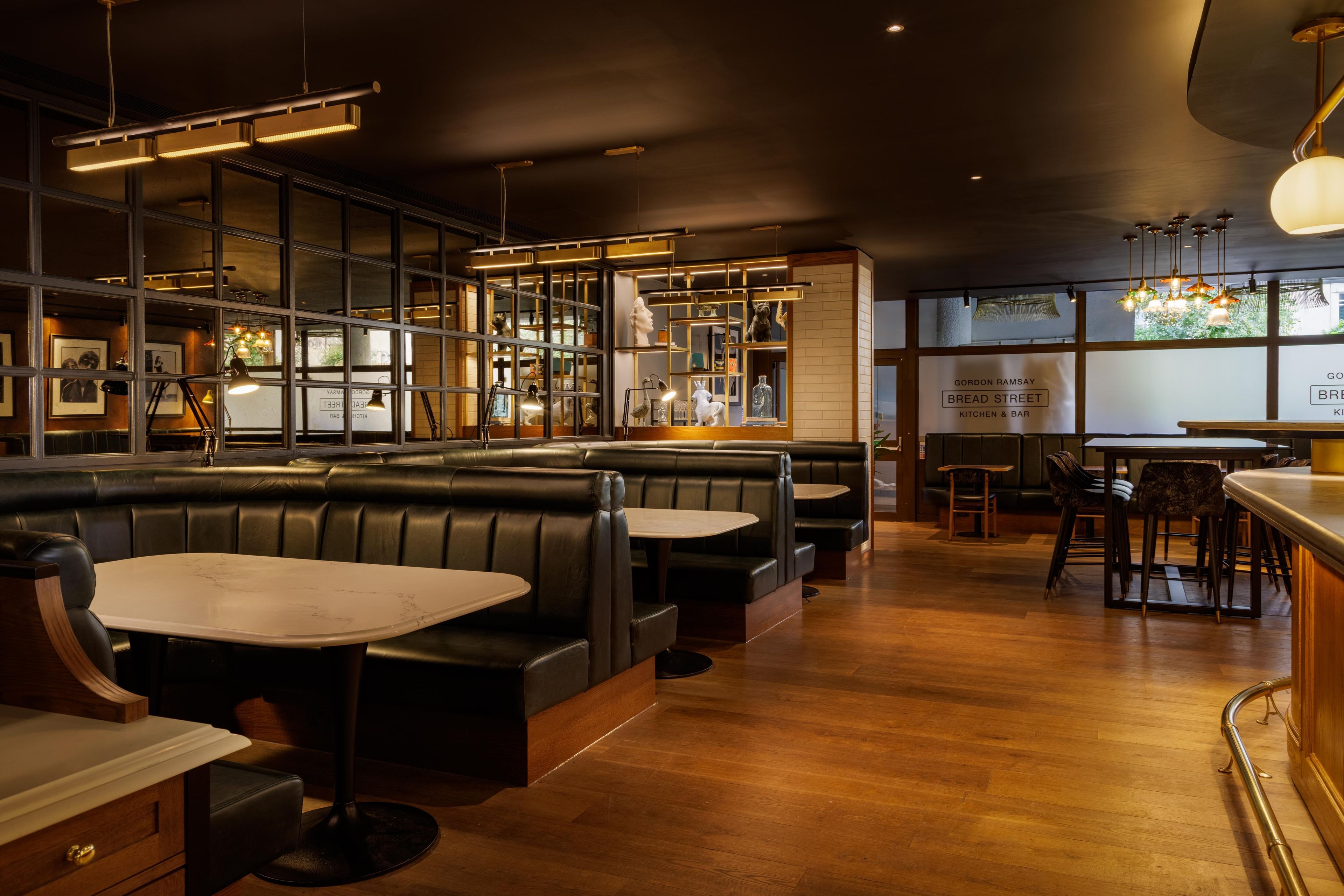 Een restaurantinterieur met zitjes, tafels en een bar.