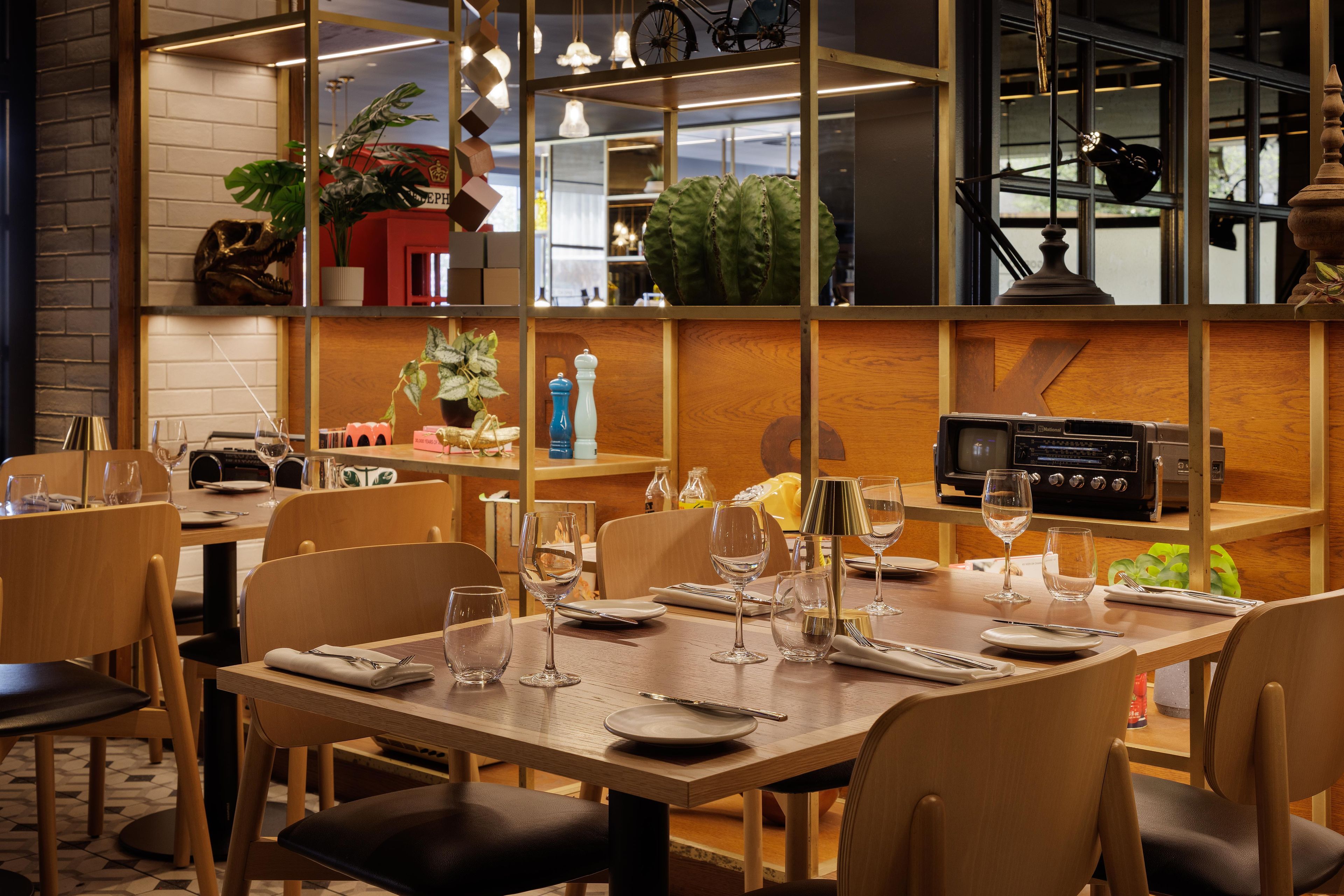 Un restaurant avec des meubles en bois, de la vaisselle en verre transparent et une radio d’époque.