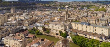 A historic cityscape with dense architecture, a prominent cathedral, and a river.
