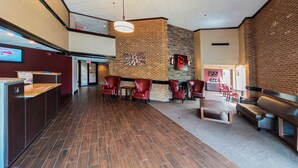 A spacious lobby with a reception desk, seating area, and a fireplace. - Red Roof Inn Raleigh Southwest - Cary (Cary)