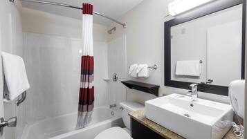 A modern bathroom with a bathtub, toilet, and sink.