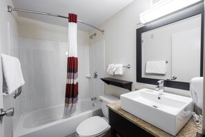 A modern bathroom with a bathtub, toilet, and sink. - Red Roof Inn Raleigh Southwest - Cary (Cary)