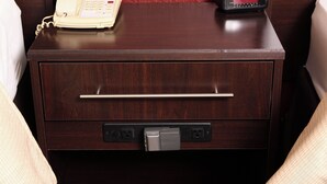 A wooden bedside table with a telephone, a drawer with a handle, and a power outlet. - Red Roof Inn Raleigh Southwest - Cary (Cary)