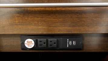 Eine Mehrfachsteckleiste mit mehreren Steckdosen und USB-Anschlüssen, beschriftet mit 'Get Plugged-In!' und 'Keek Rooft''.