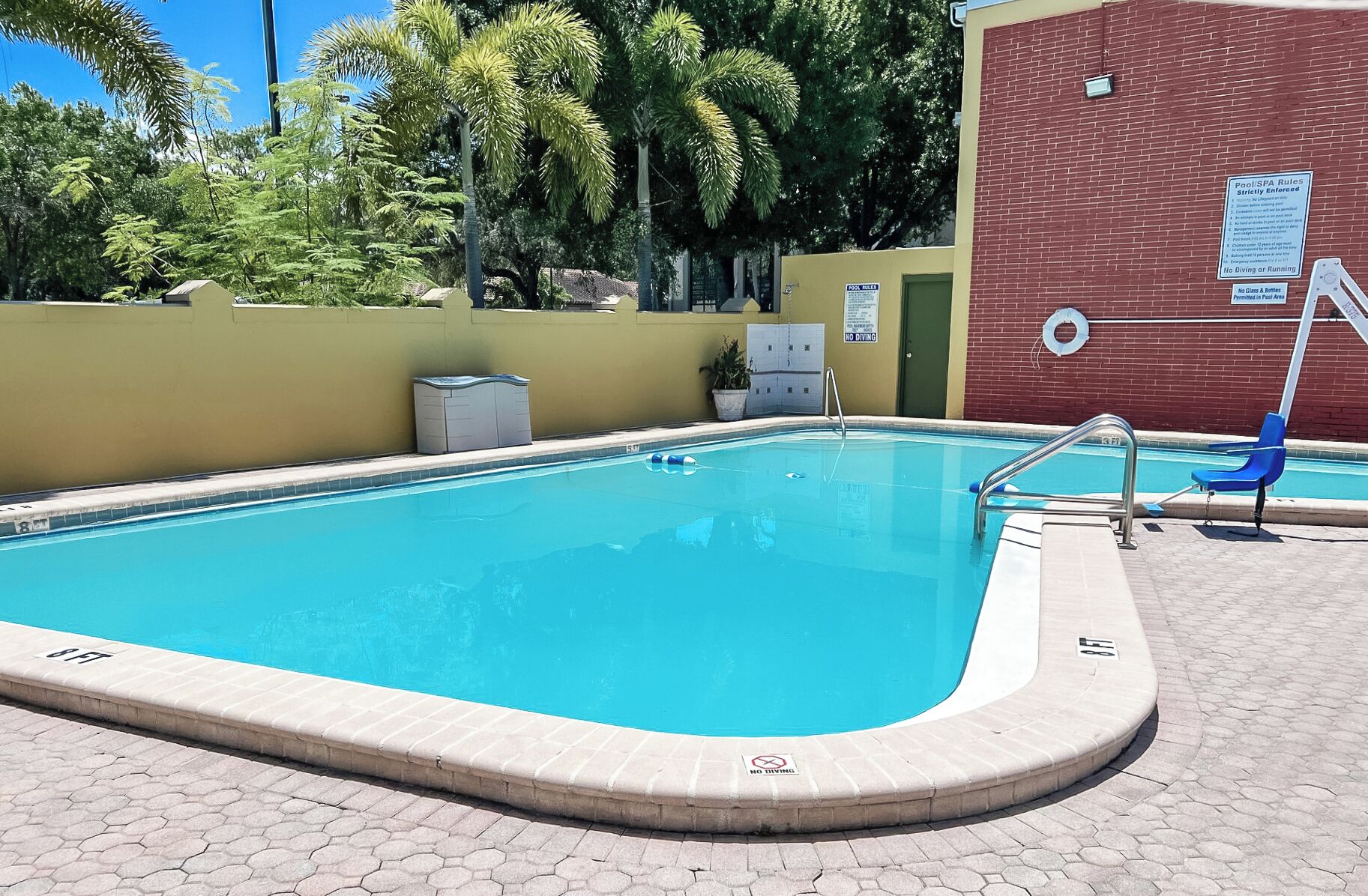 Una piscina con una escalera, un flotador salvavidas y un letrero que indica 'No Diving'.