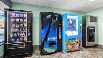 Máquinas expendedoras con aperitivos y una escena de playa tropical, una máquina expendedora de helado y otra máquina expendedora con una escena de playa tropical.