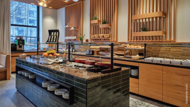 A modern breakfast bar with a variety of food items, a coffee station, and a view of the city. - Dorint City-Hotel Salzburg (Salzburg)