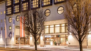 A modern building with multiple windows and a large entrance. - Dorint City-Hotel Salzburg (Salzburg)